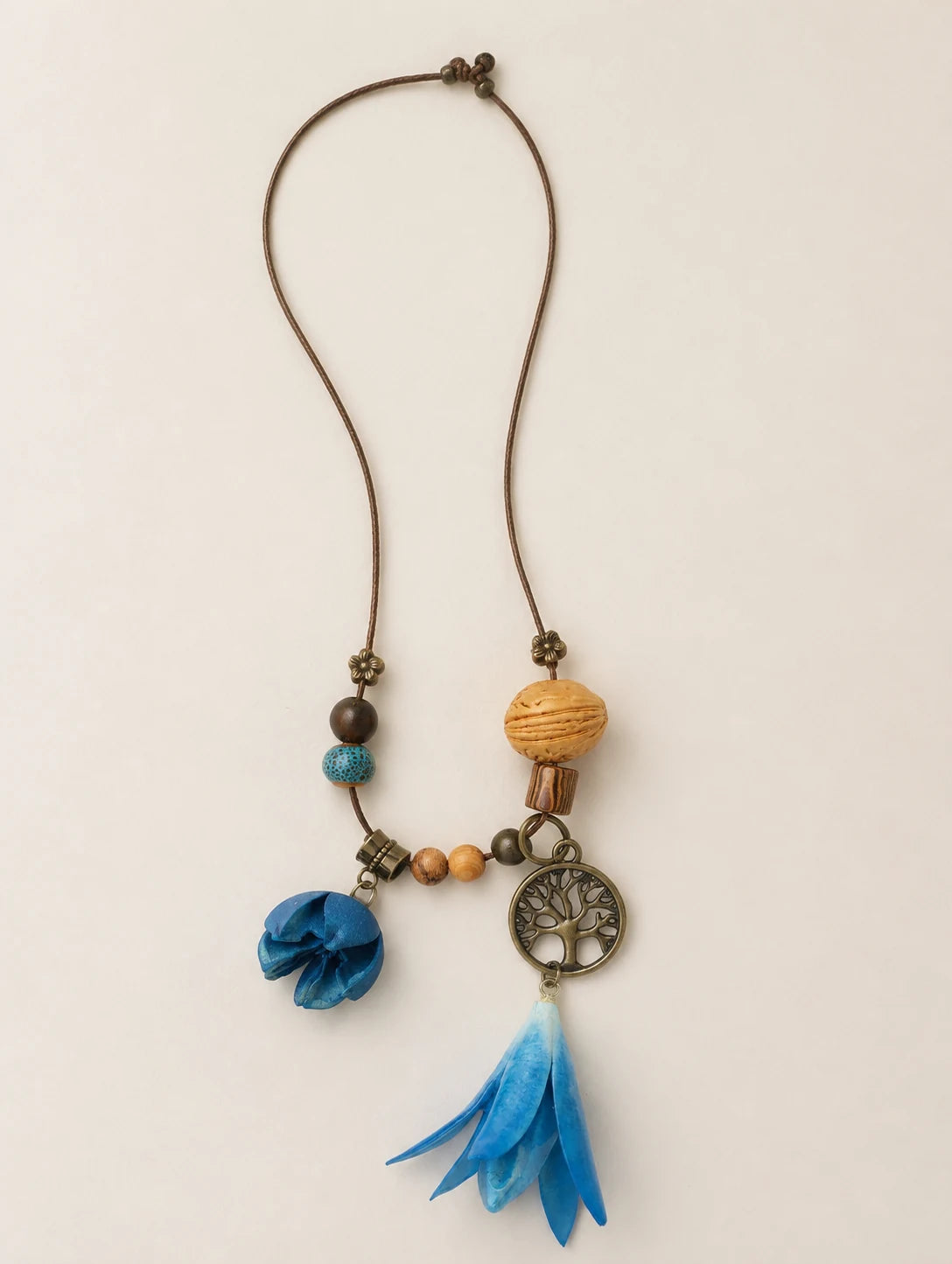 Blue Bell Petal Necklace — complete product view on a warm ivory background