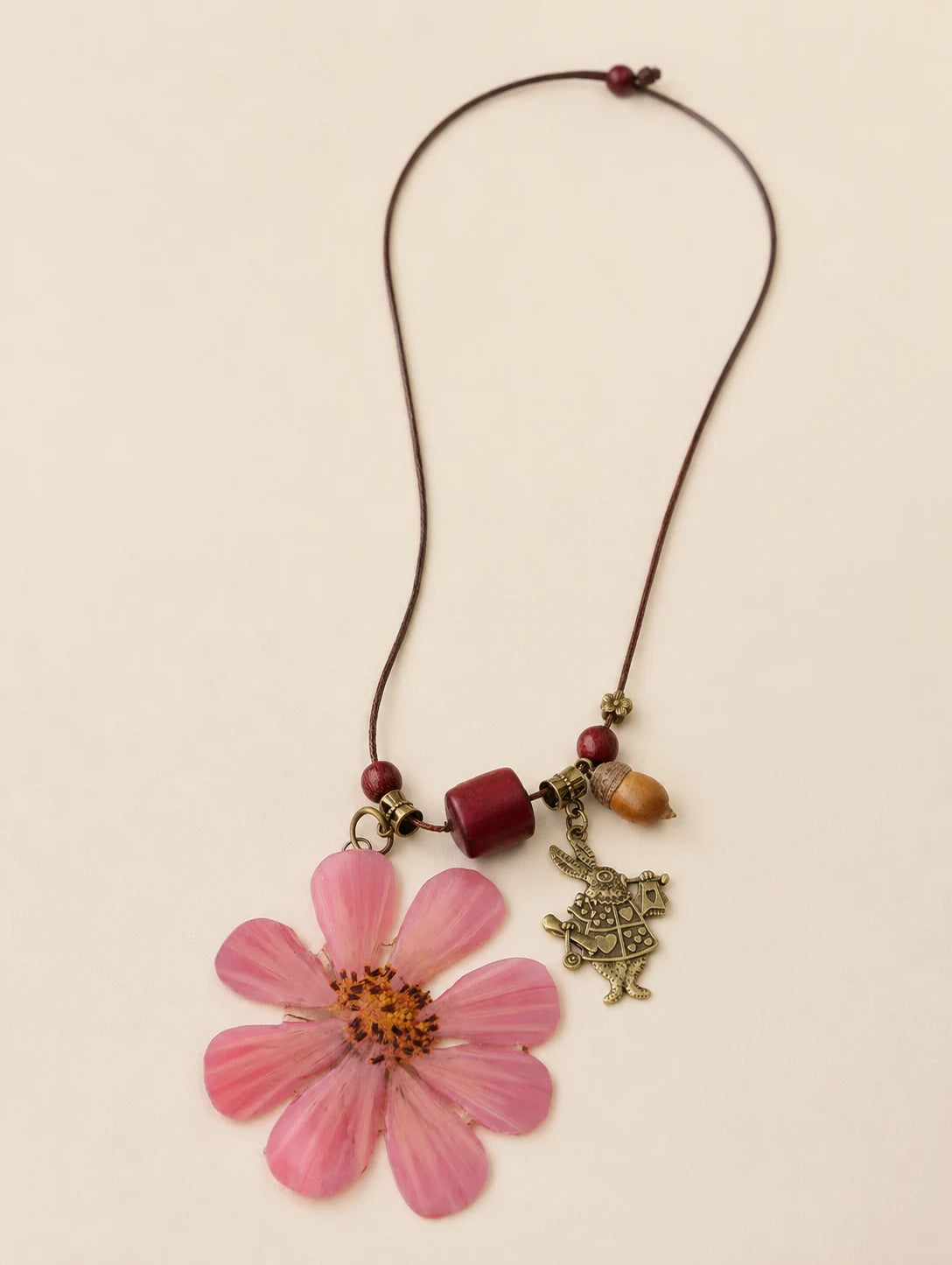 Pink Petal Pendant Necklace — complete product view on a warm ivory background