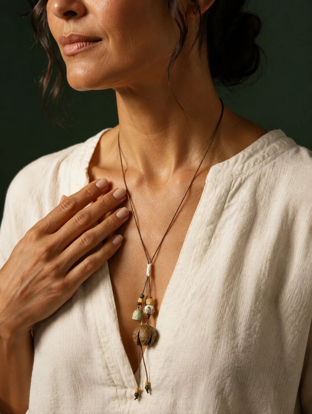 Model styling a woodland-inspired pendant necklace in soft editorial light