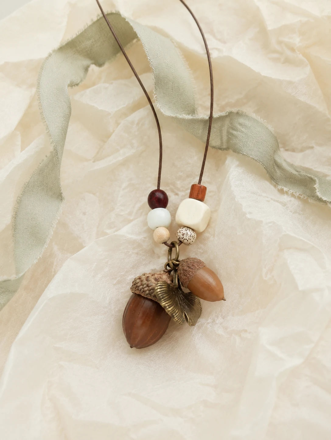 Brown Acorn-Silhouette Necklace — unbranded gift-context still life