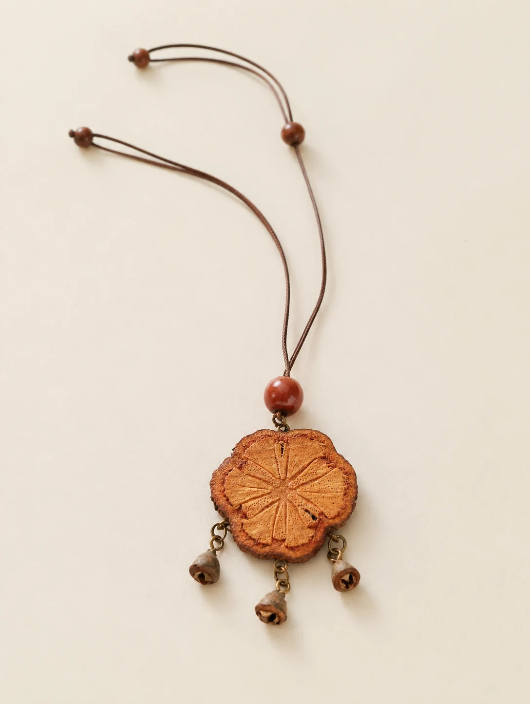Carved Wood Tassel Necklace — complete product view on a warm ivory background
