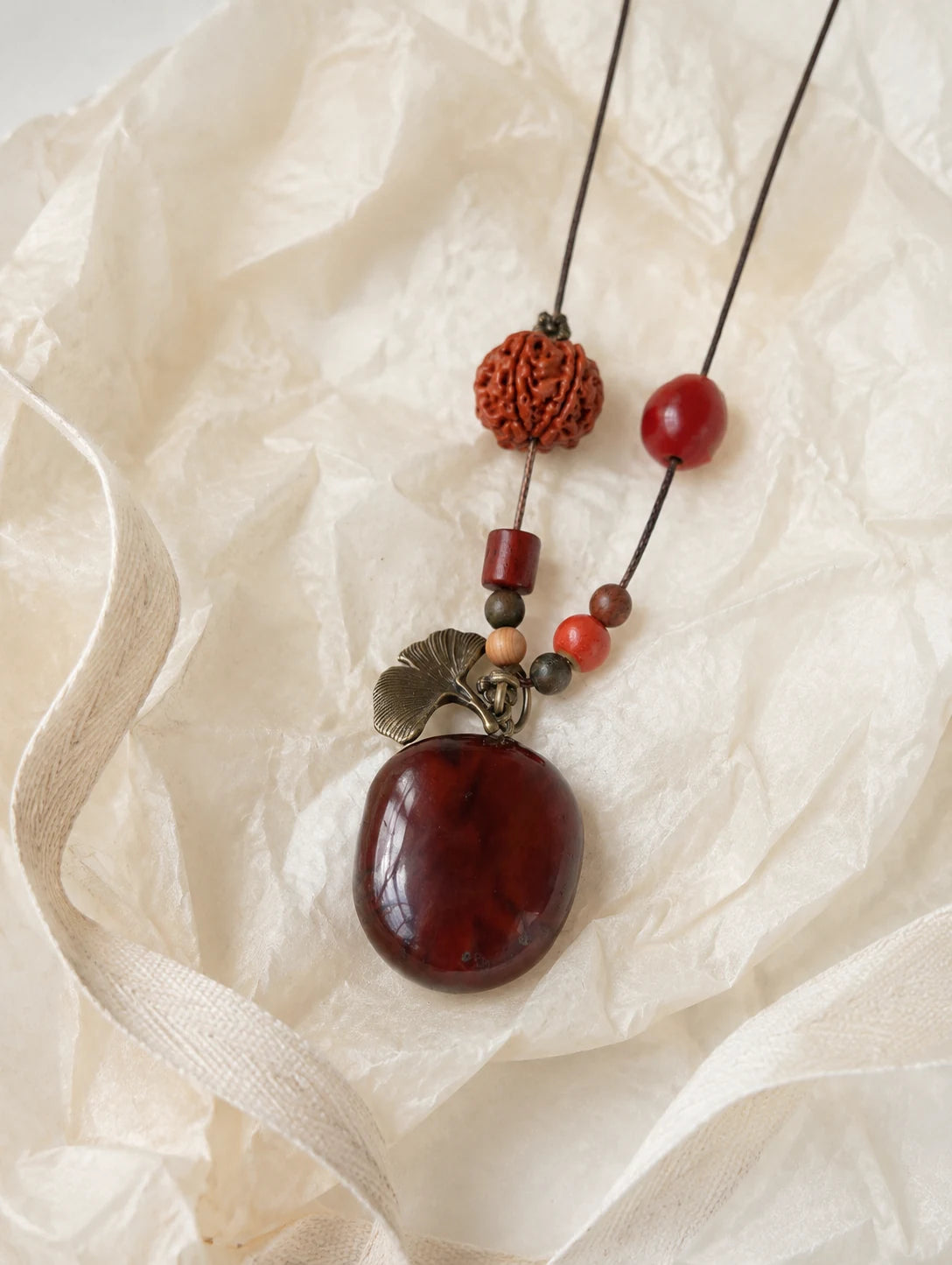 Deep Red Seed Pendant Necklace — unbranded gift-context still life