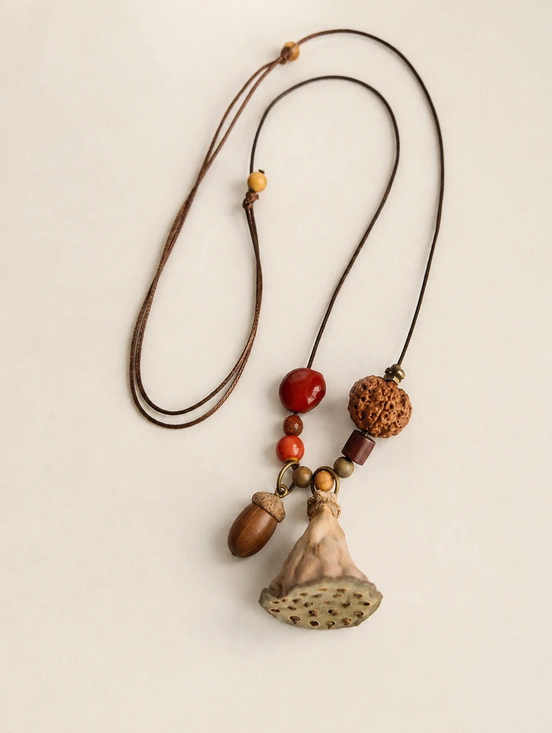 Fan Pod and Acorn Necklace — complete product view on a warm ivory background