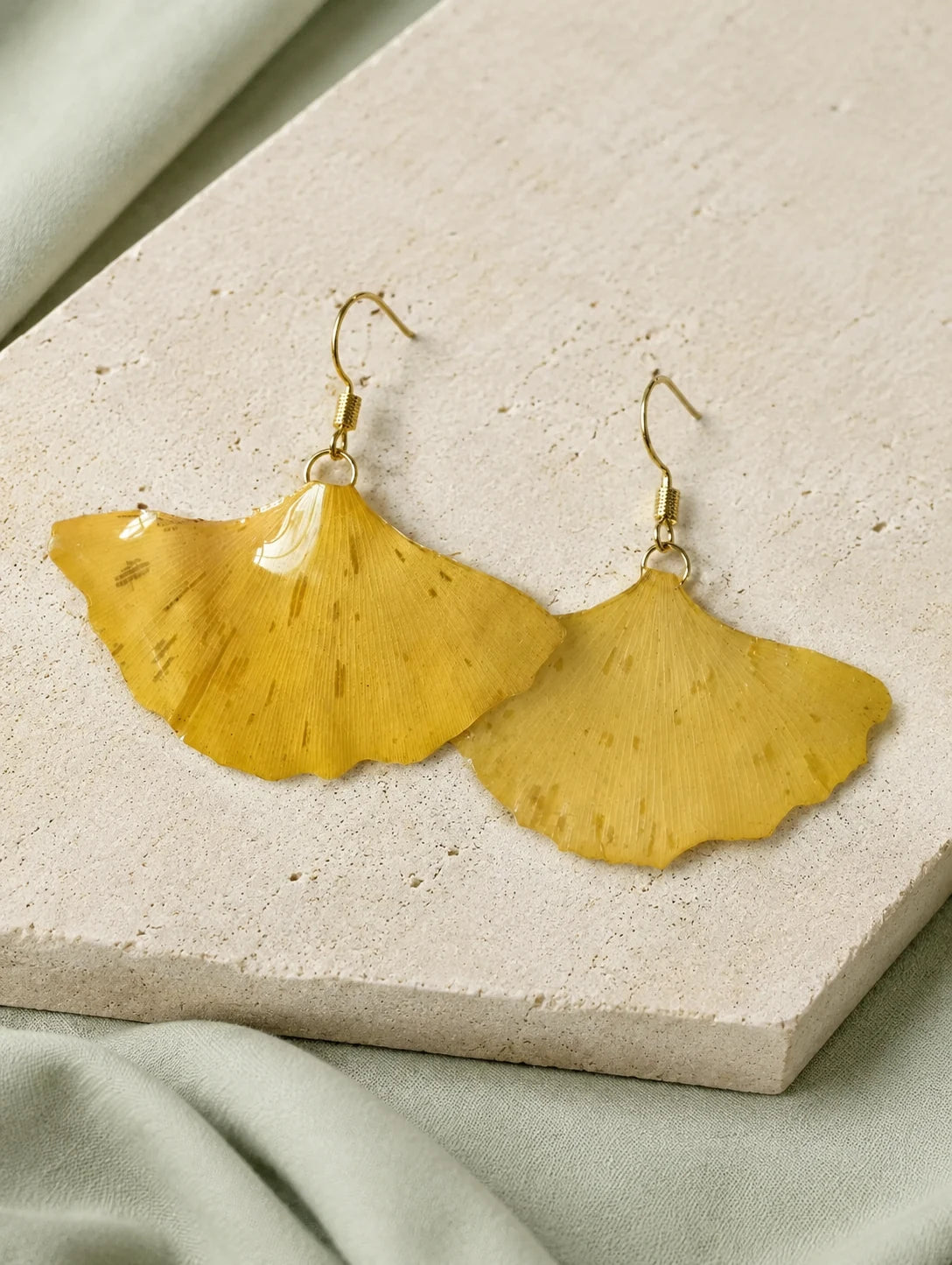 Golden Fan Leaf Drop Earrings — restrained editorial still life