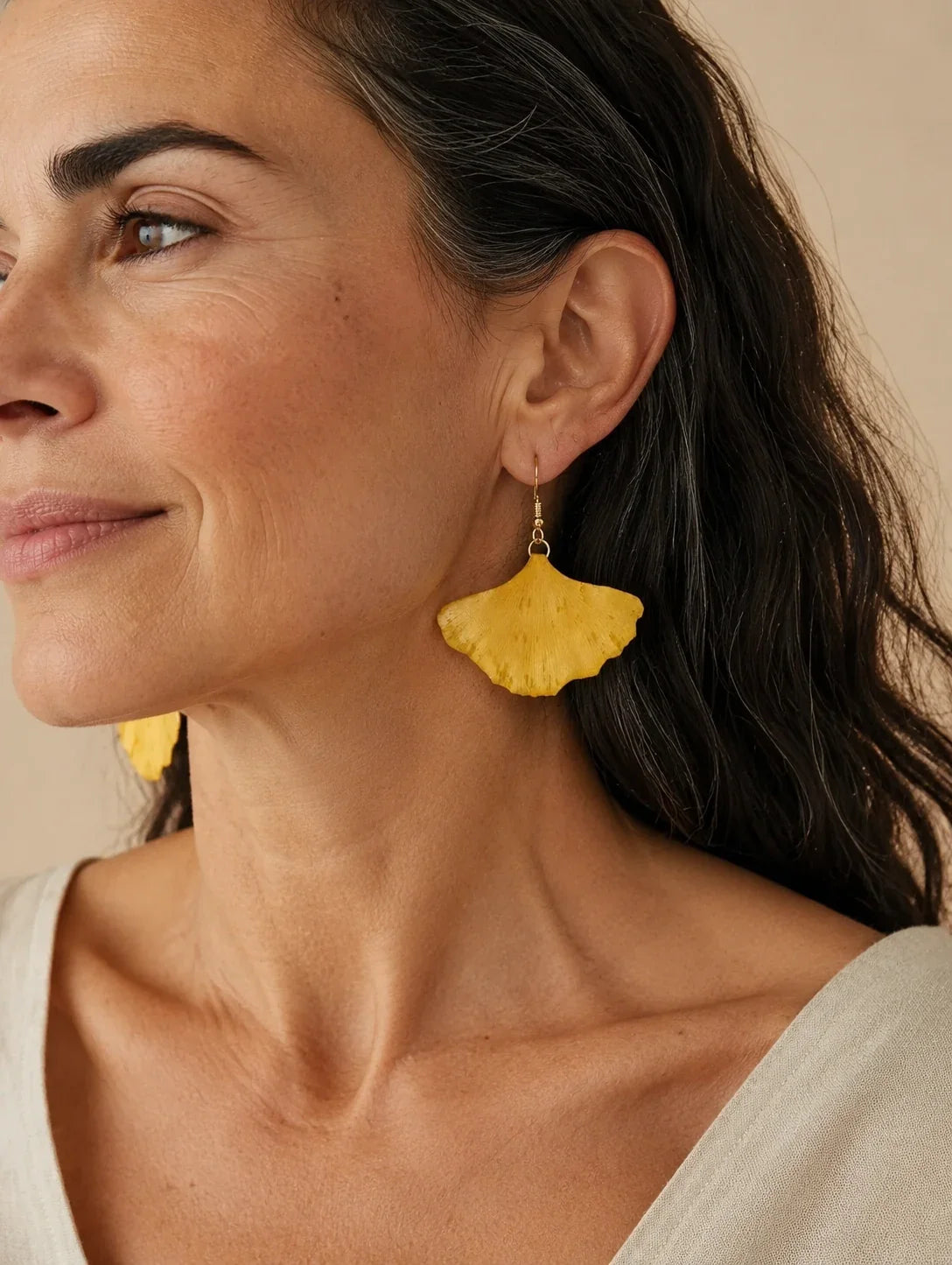 Editorial model styling the Golden Fan Leaf Drop Earrings