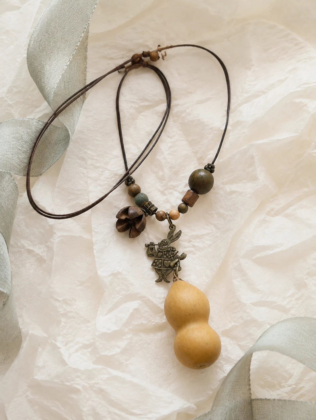 Golden Gourd-Silhouette Necklace — unbranded gift-context still life