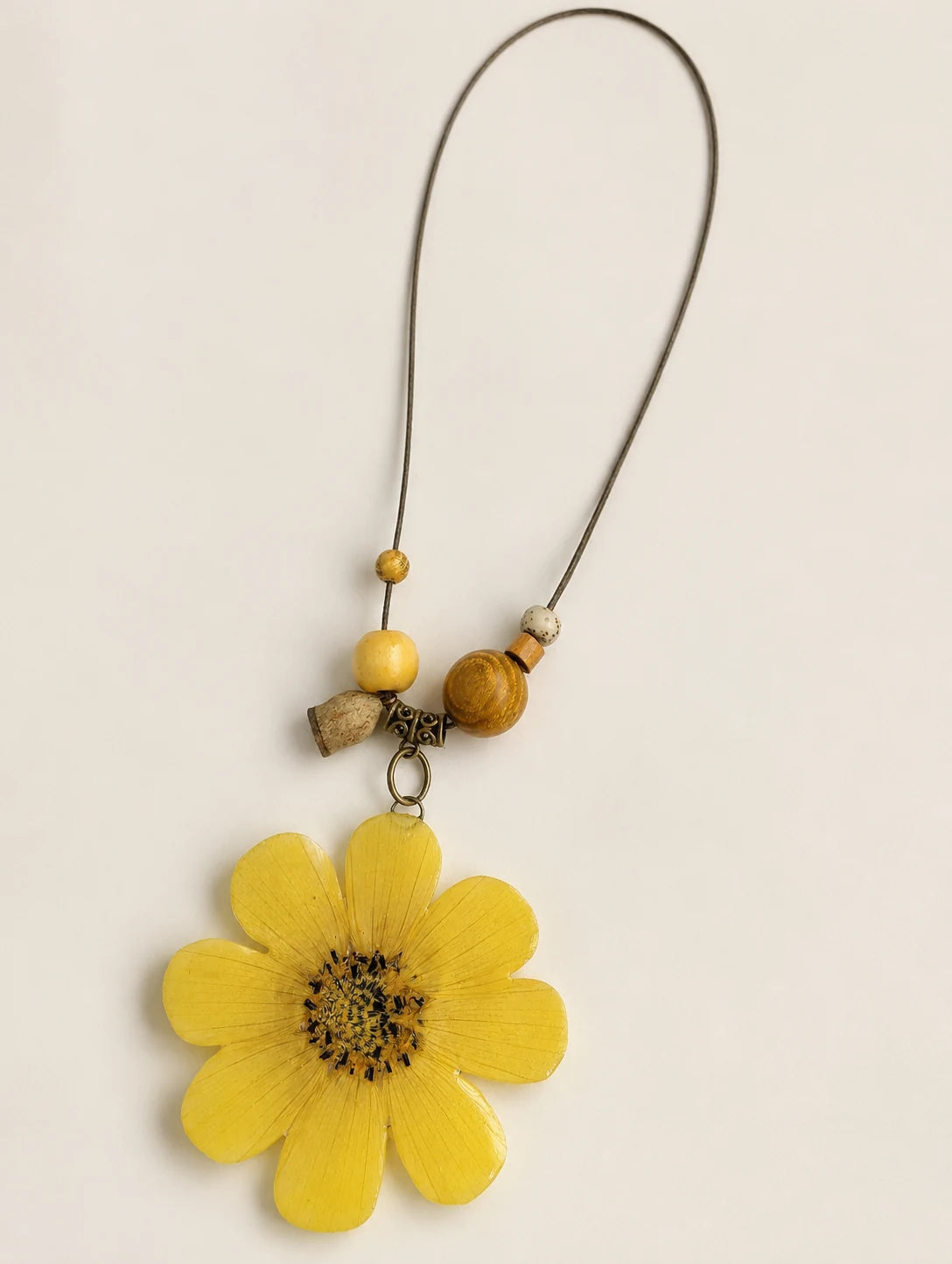 Golden Petal Pendant Necklace — complete product view on a warm ivory background
