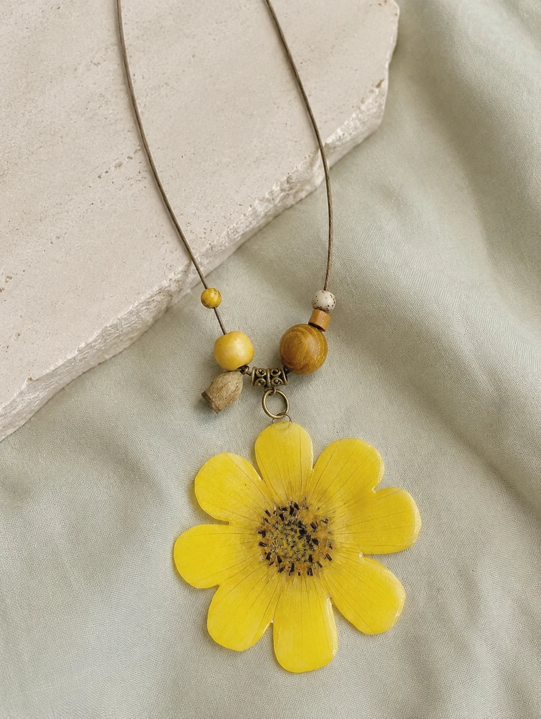 Golden Petal Pendant Necklace — restrained editorial still life