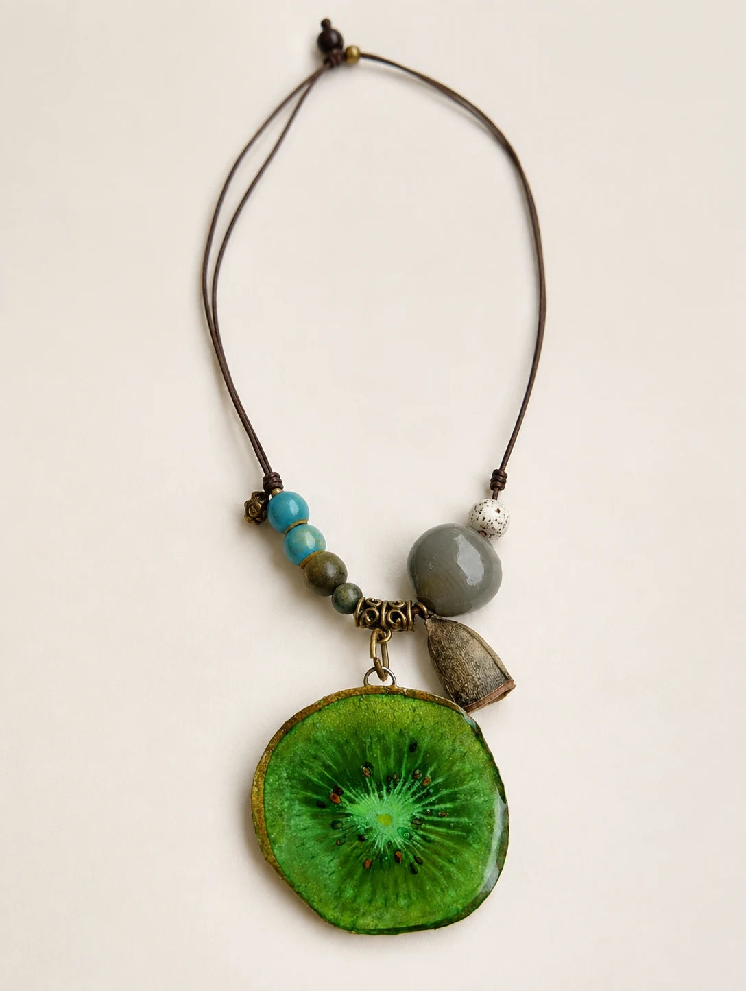 Green Slice and Bead Necklace — complete product view on a warm ivory background