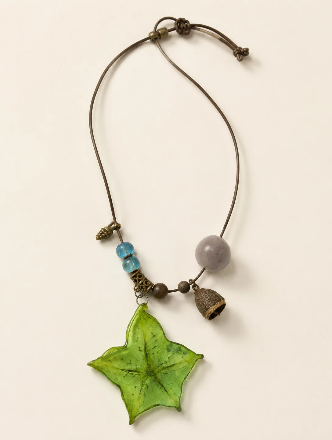 Green Star Slice Necklace — complete product view on a warm ivory background