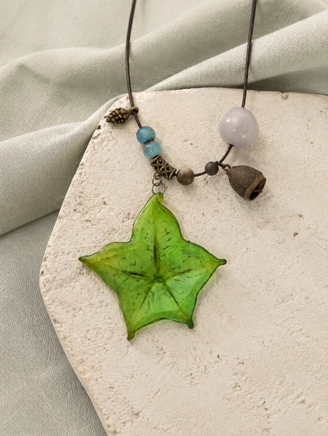 Green Star Slice Necklace — restrained editorial still life