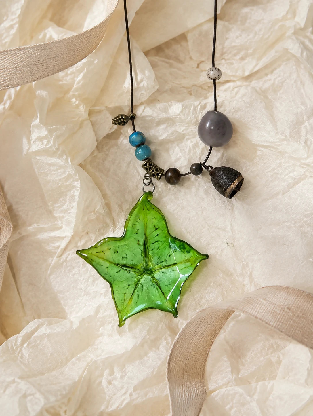 Green Star Slice Necklace — unbranded gift-context still life