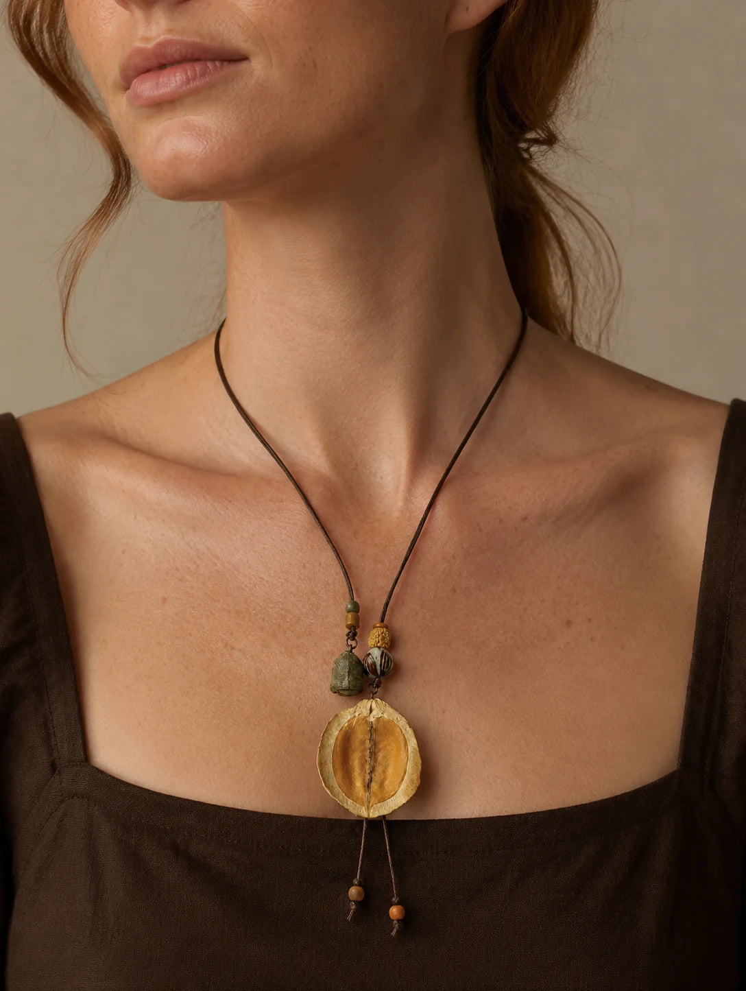 Editorial model styling the Curved Seed-Pod Pendant Necklace