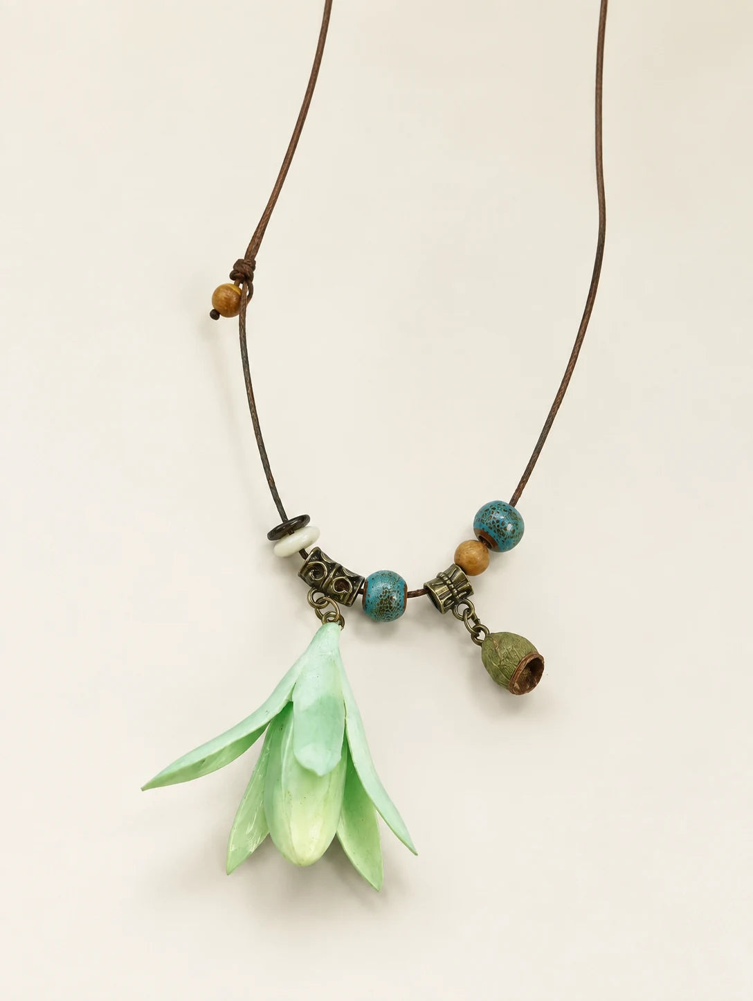 Mint Bell Petal Pendant Necklace — complete product view on a warm ivory background