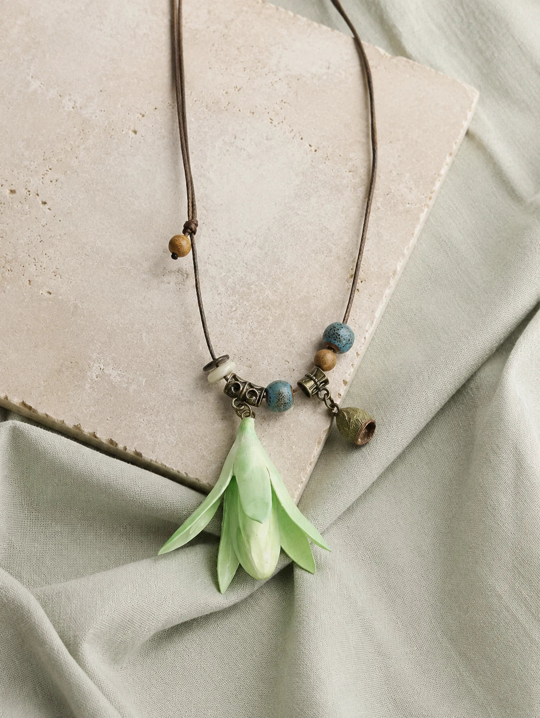 Mint Bell Petal Pendant Necklace — restrained editorial still life