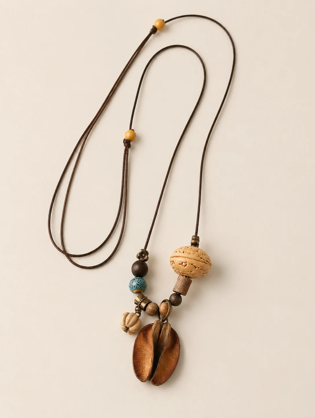 Mixed Woodland Token Necklace — complete product view on a warm ivory background