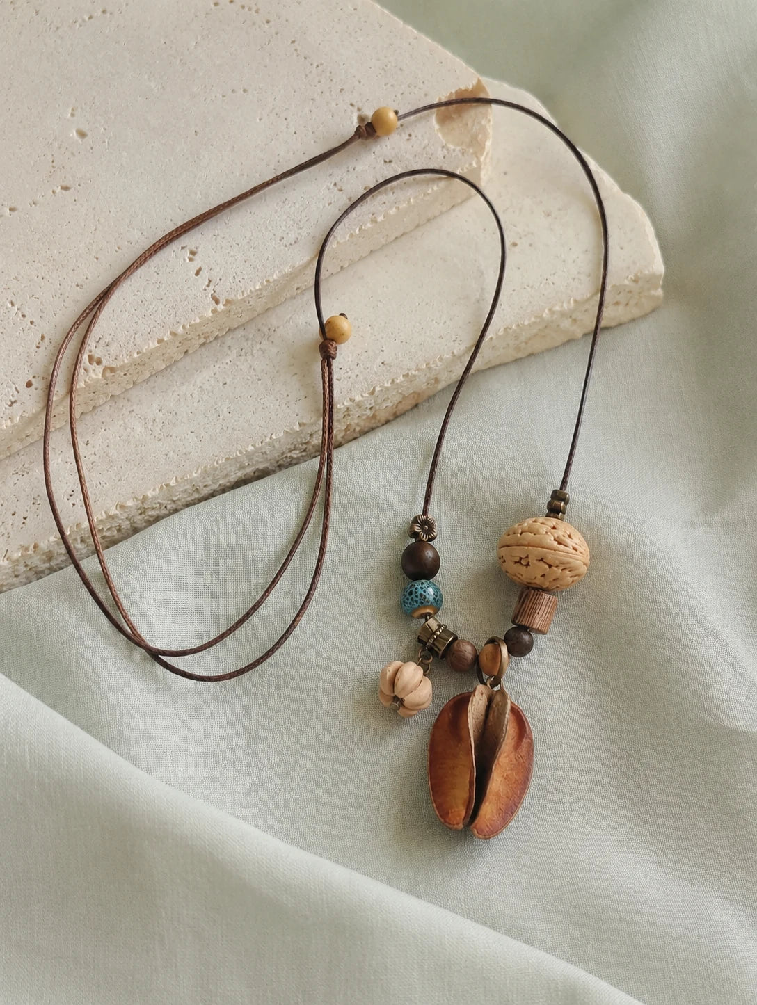 Mixed Woodland Token Necklace — restrained editorial still life
