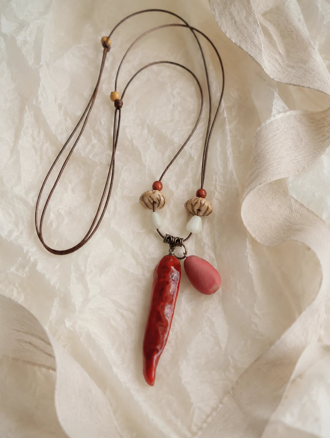 Red Pod and Bead Necklace — unbranded gift-context still life