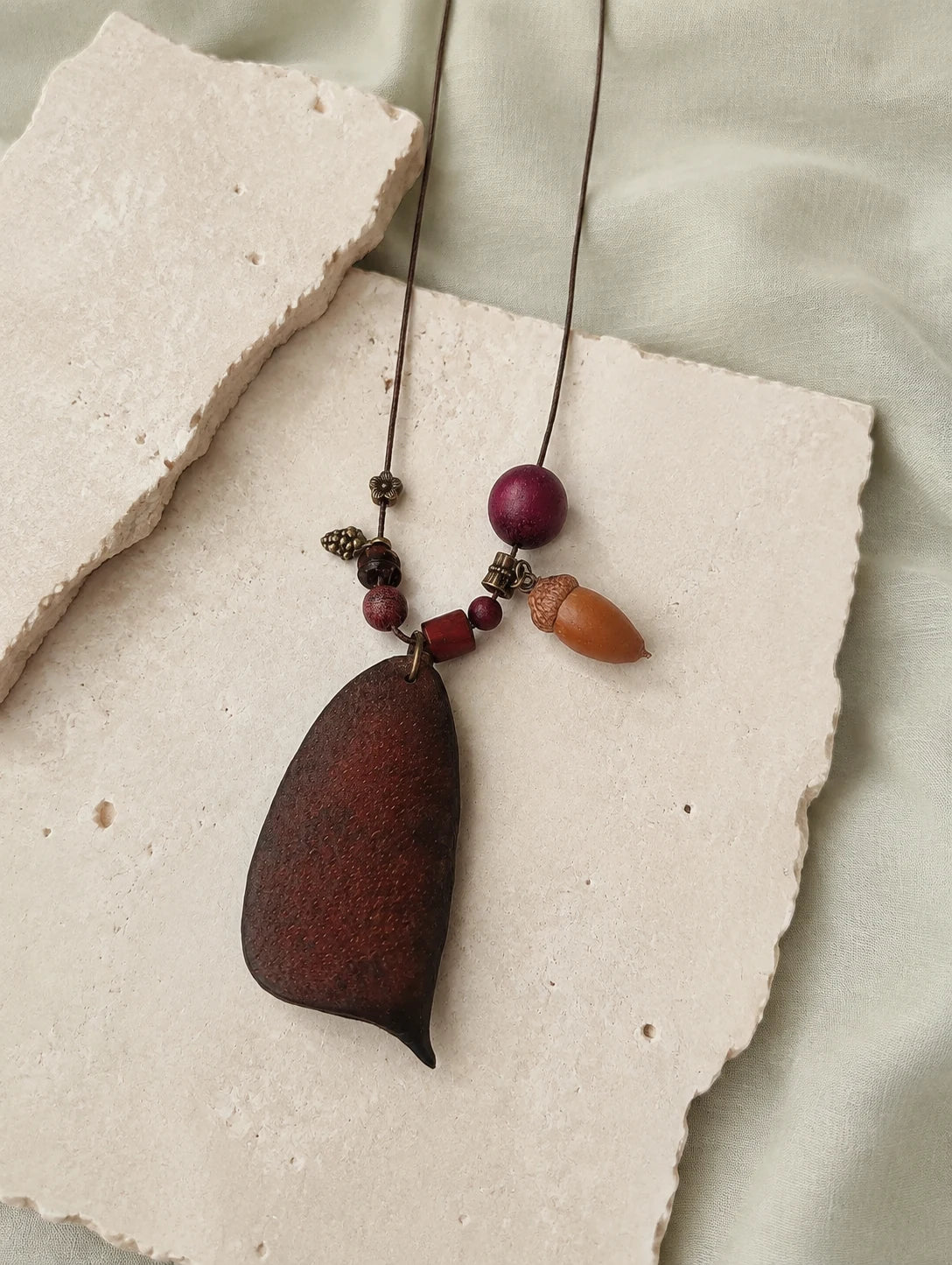 Seed Pod and Acorn Necklace — restrained editorial still life