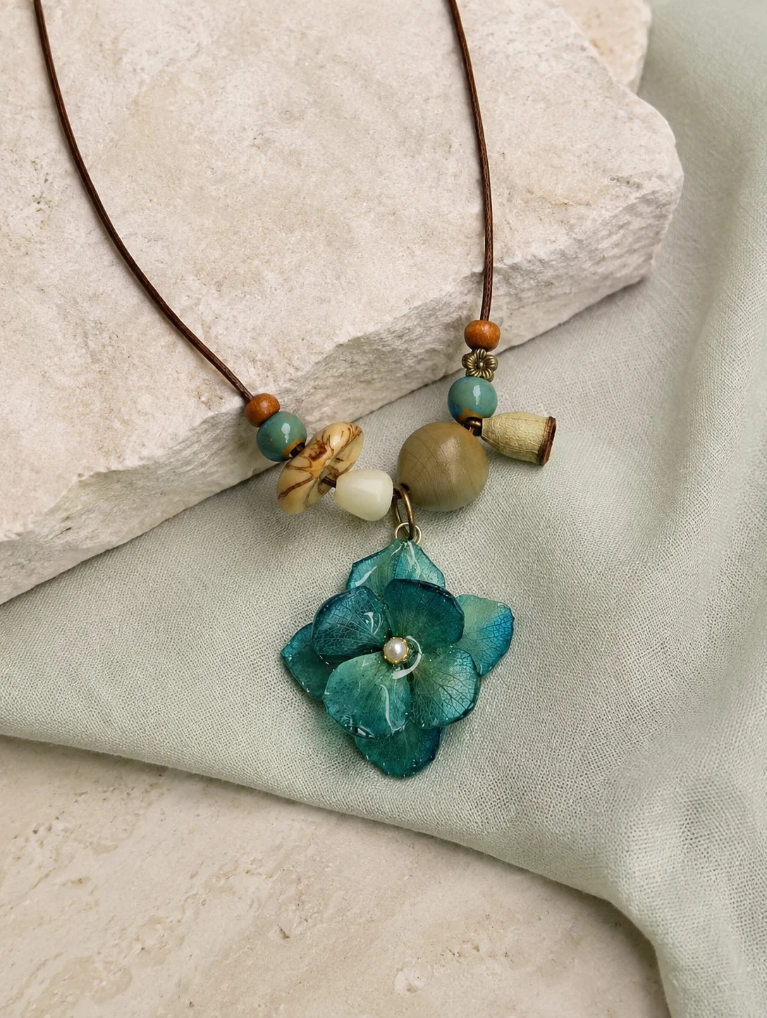 Teal Petal Cluster Necklace — restrained editorial still life