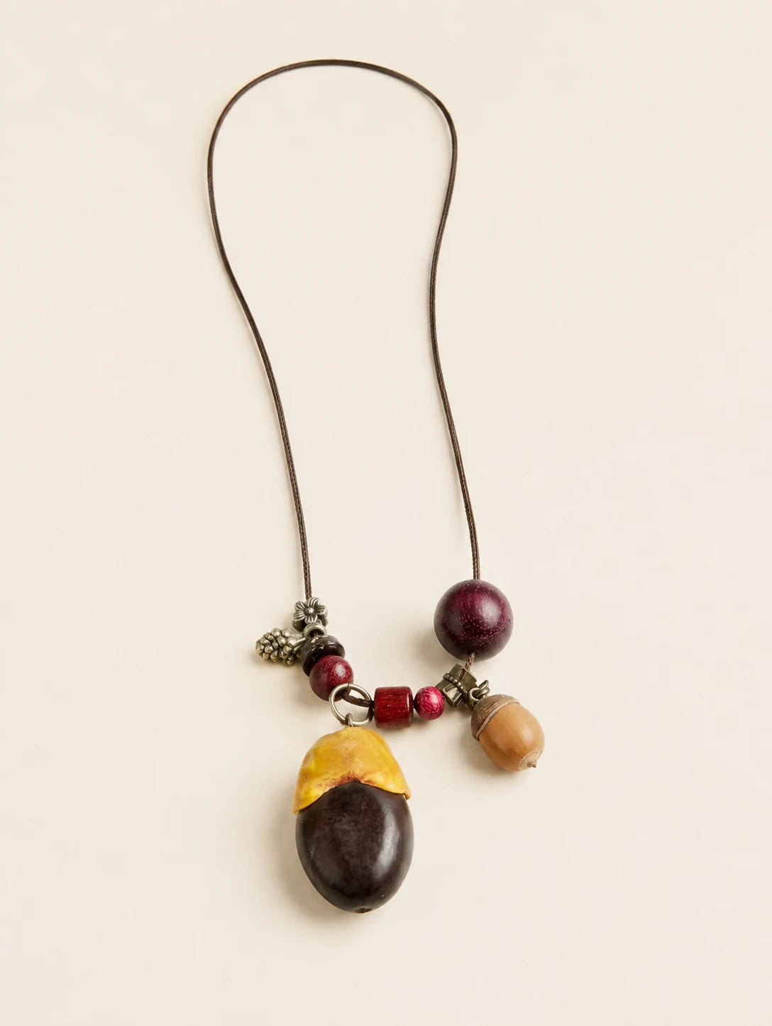 Two-Tone Seed Pendant Necklace — complete product view on a warm ivory background