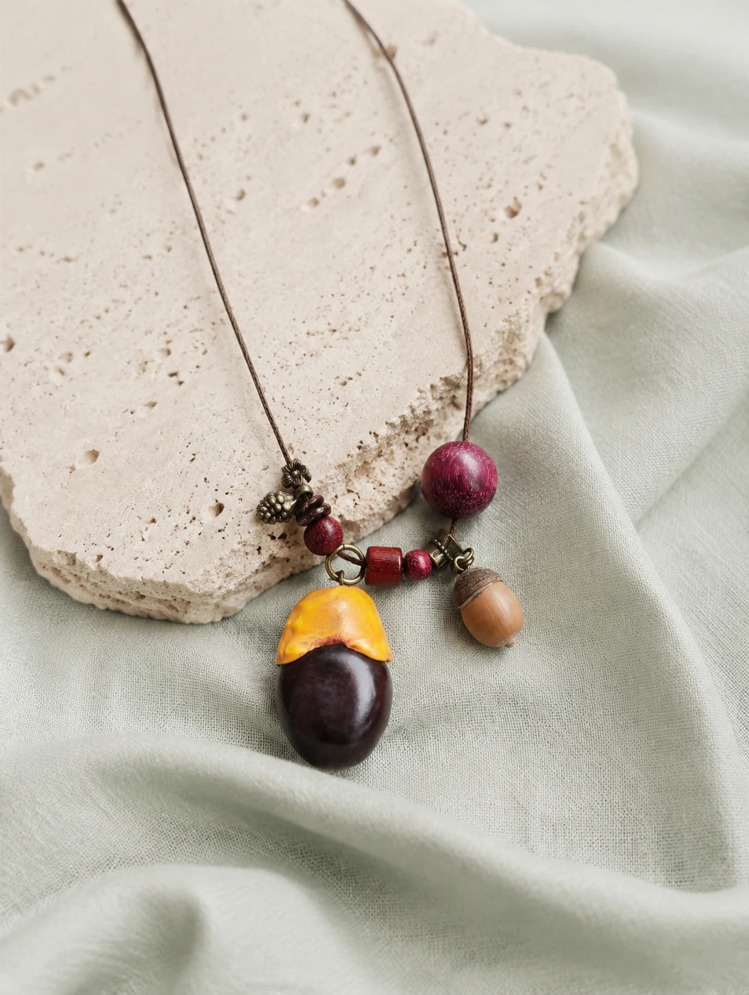 Two-Tone Seed Pendant Necklace — restrained editorial still life