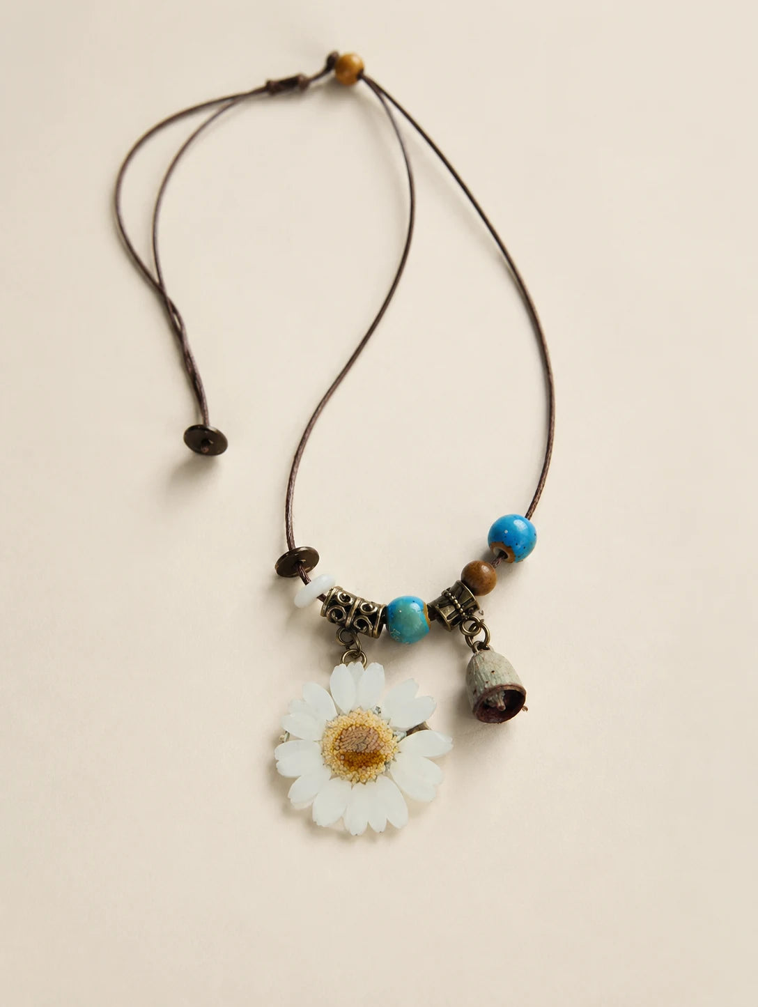White Petal Token Necklace — complete product view on a warm ivory background
