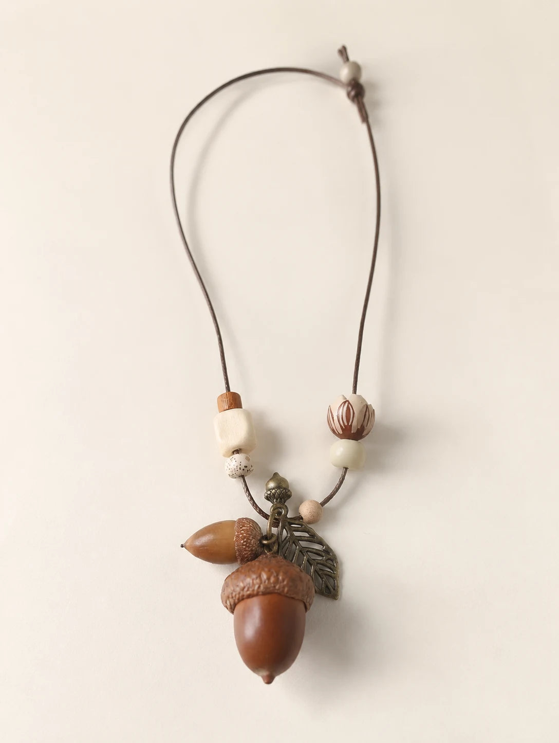 Woodland Acorn Cluster Necklace — complete product view on a warm ivory background