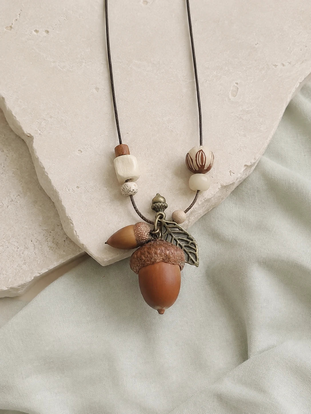 Woodland Acorn Cluster Necklace — restrained editorial still life