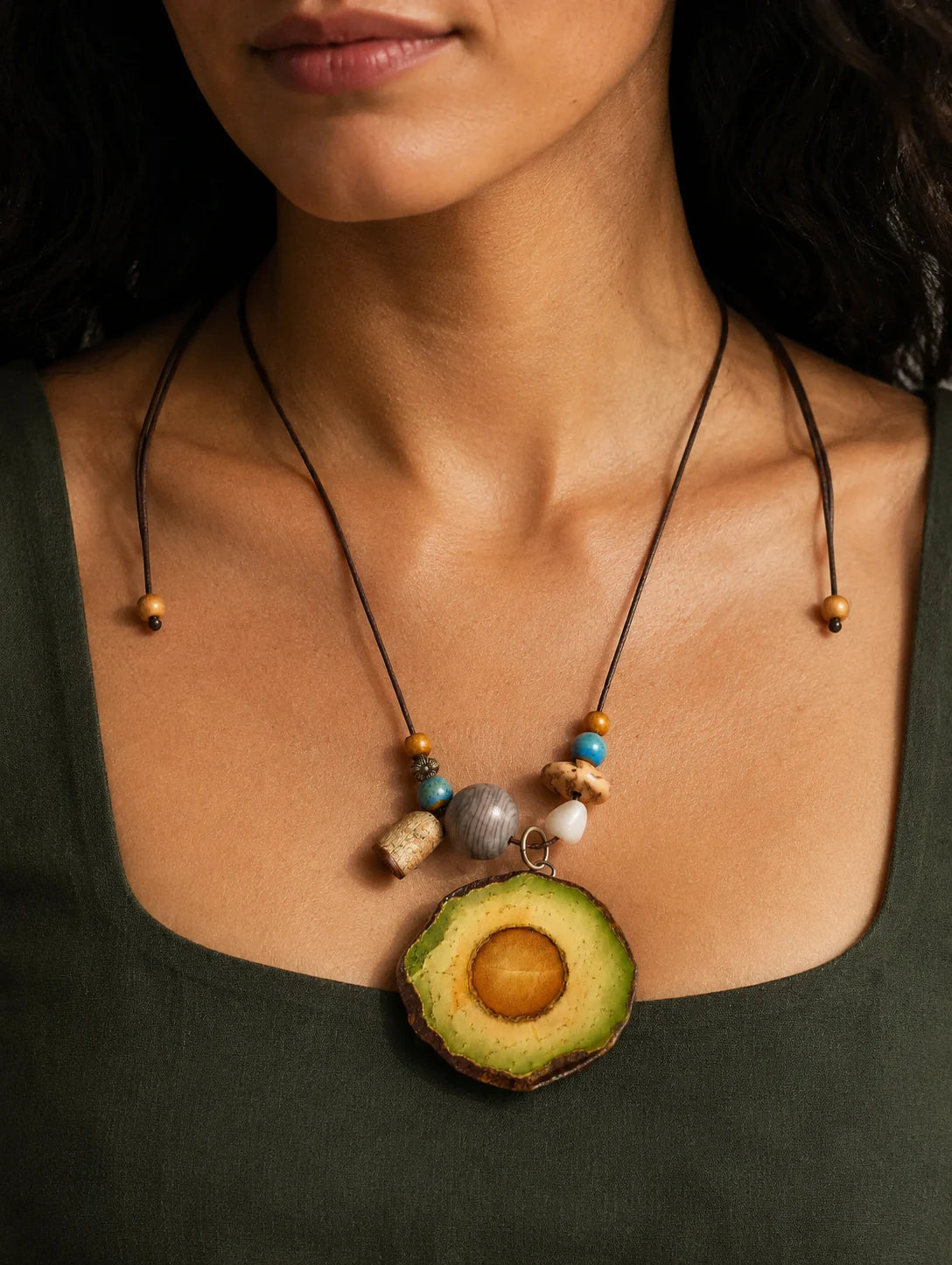 Model styling a green botanical-inspired pendant necklace