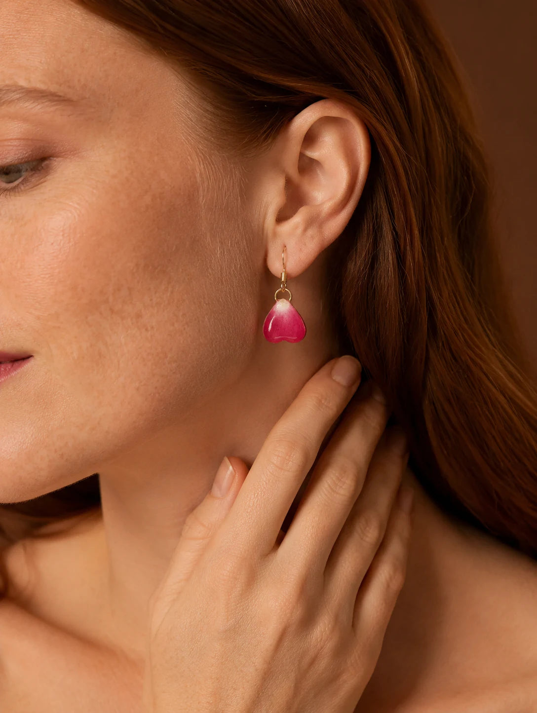 Close-up of a model wearing rose heart botanical-inspired earrings